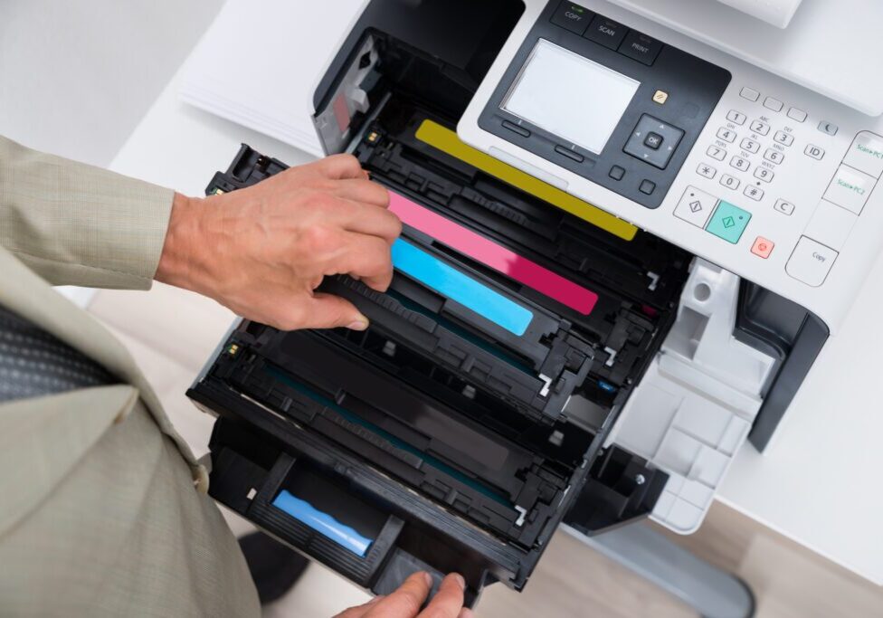Cropped image of businessman fixing cartridge in photocopy machine at office